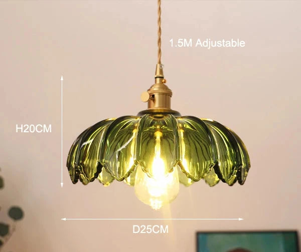 Inaya Pendant light featuring a floral-inspired design with a colored glass shade. Available in various colorways, this statement pendant has an adjustable height, blending whimsy and sophistication. Ideal for home decor enthusiasts seeking unique, artistic lighting for their space.