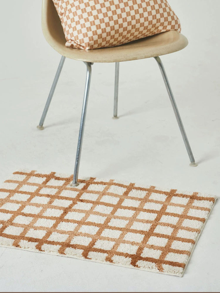Modern checkered bath mat in warm colorways, striped design. Elevate your bathroom décor.