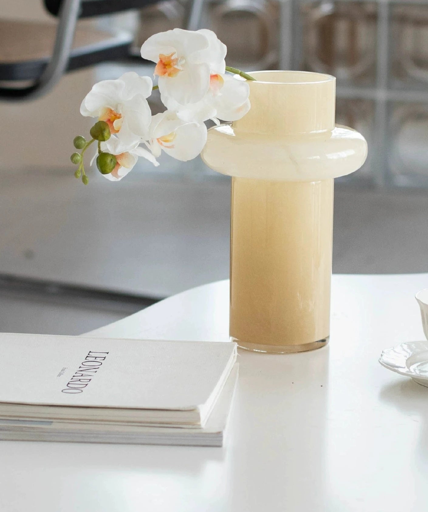 Modern glass vase in cream, ideal for home décor.