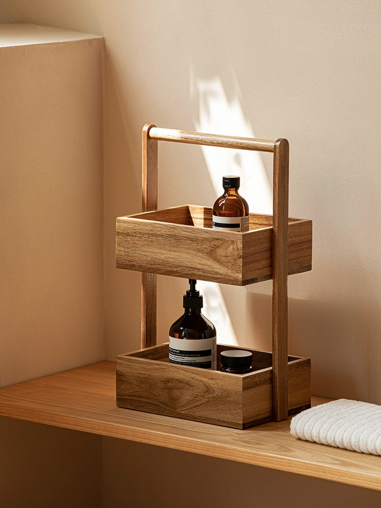 The Jacko Storage Rack features two levels made from solid acacia wood with a warm brown tone. Its simple and minimalist design makes it perfect for organizing countertops in kitchens, bathrooms, or any room in the home. This compact and stylish storage rack helps declutter while adding a touch of natural elegance, ideal for home décor enthusiasts seeking both functionality and aesthetic appeal.