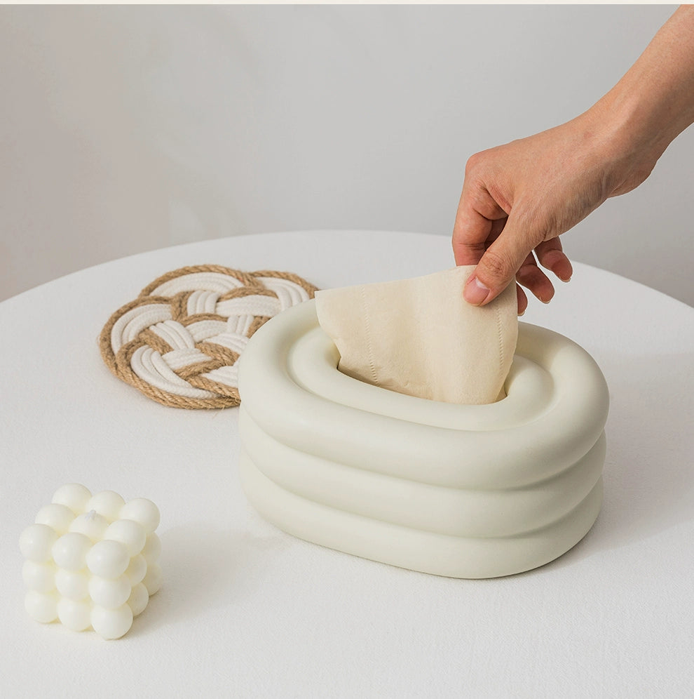 A modern ceramic tissue box cover with an oval shape, available in various stylish colorways. The cover adds a touch of contemporary elegance to home decor, seamlessly concealing tissue boxes while maintaining functional and chic design.