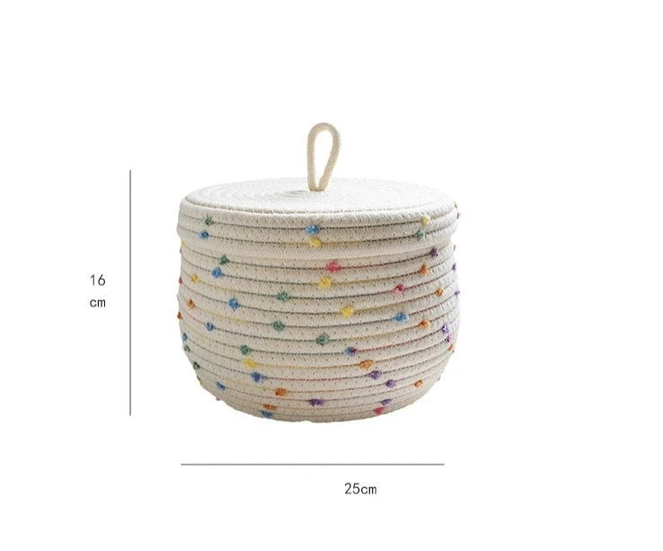 Kids' cream basket with colorful pom poms for toy and clothing storage.