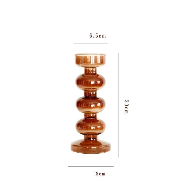 A brown glass Rhea Candle Holder set, featuring four different silhouettes in various sizes, creating a warm and inviting retro ambiance.
