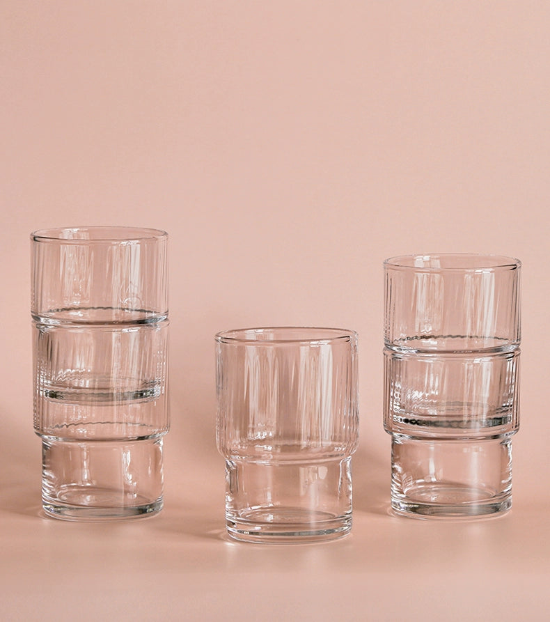 A set of Lyle Stackable Glasses, featuring sleek and minimalistic design. The glasses are crafted from high-quality, clear glass and are stackable for easy storage. Each glass holds 12 ounces, making them ideal for everyday use or entertaining. Perfect for home décor enthusiasts looking to add functional and stylish glassware to their kitchen or dining space.