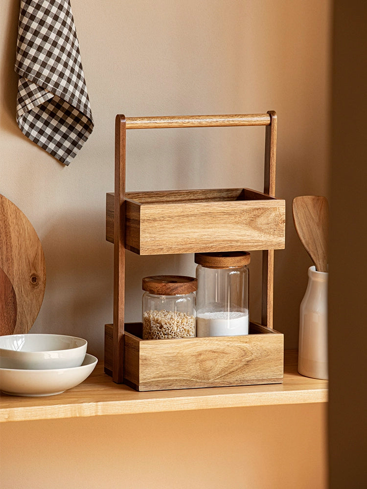 The Jacko Storage Rack features two levels made from solid acacia wood with a warm brown tone. Its simple and minimalist design makes it perfect for organizing countertops in kitchens, bathrooms, or any room in the home. This compact and stylish storage rack helps declutter while adding a touch of natural elegance, ideal for home décor enthusiasts seeking both functionality and aesthetic appeal.