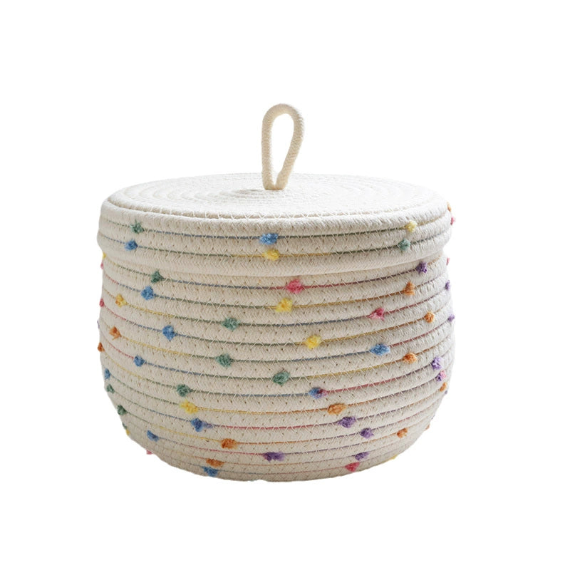 Kids' cream basket with colorful pom poms for toy and clothing storage.