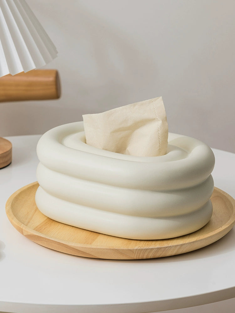 A modern ceramic tissue box cover with an oval shape, available in various stylish colorways. The cover adds a touch of contemporary elegance to home decor, seamlessly concealing tissue boxes while maintaining functional and chic design.