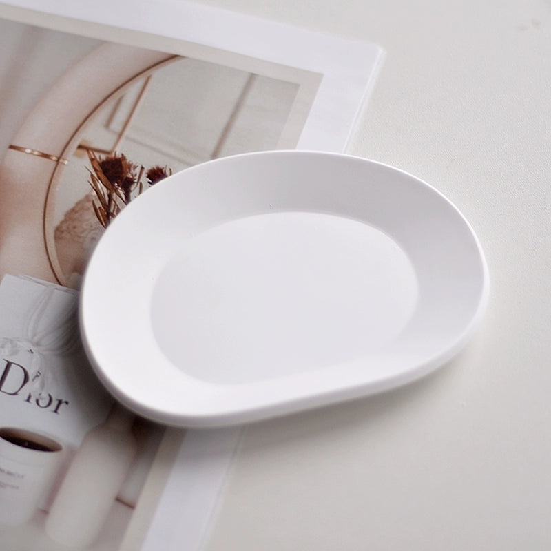 A collection of plaster trays from the Quinto Tray Collection, featuring various shapes and neutral colorways, suitable for use in different areas of the home.