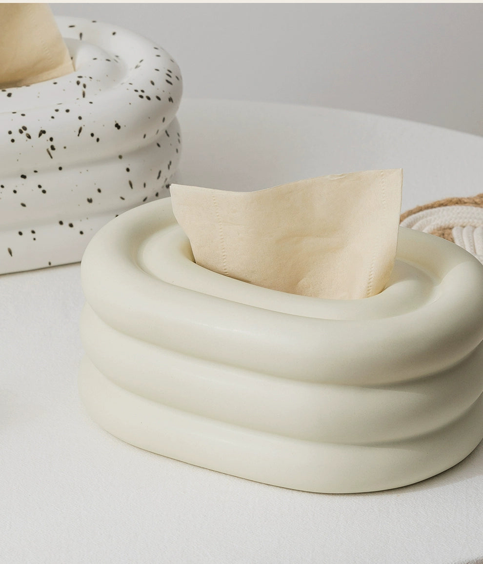 A modern ceramic tissue box cover with an oval shape, available in various stylish colorways. The cover adds a touch of contemporary elegance to home decor, seamlessly concealing tissue boxes while maintaining functional and chic design.