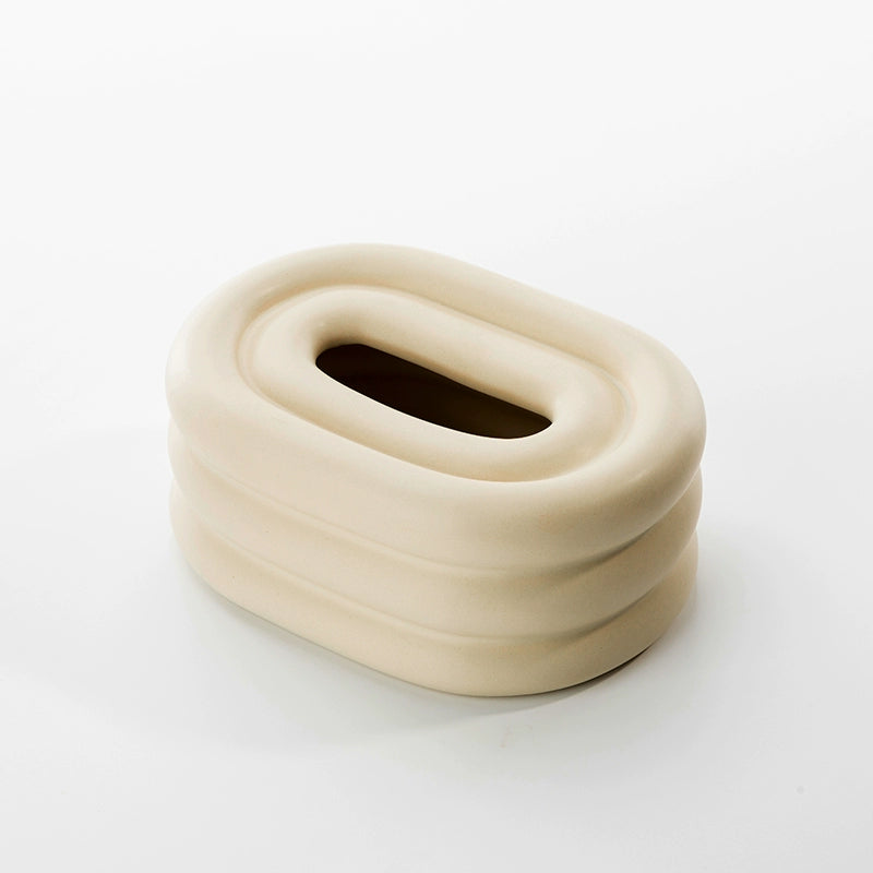A modern ceramic tissue box cover with an oval shape, available in various stylish colorways. The cover adds a touch of contemporary elegance to home decor, seamlessly concealing tissue boxes while maintaining functional and chic design.