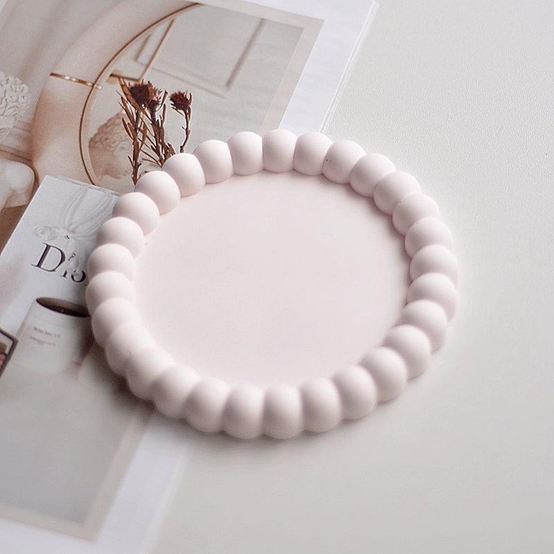 A collection of plaster trays from the Quinto Tray Collection, featuring various shapes and neutral colorways, suitable for use in different areas of the home.