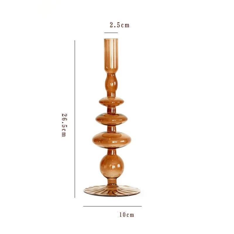A brown glass Rhea Candle Holder set, featuring four different silhouettes in various sizes, creating a warm and inviting retro ambiance.