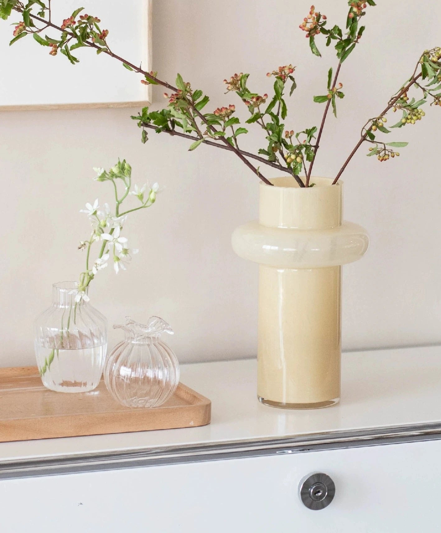 Modern glass vase in cream, ideal for home décor.
