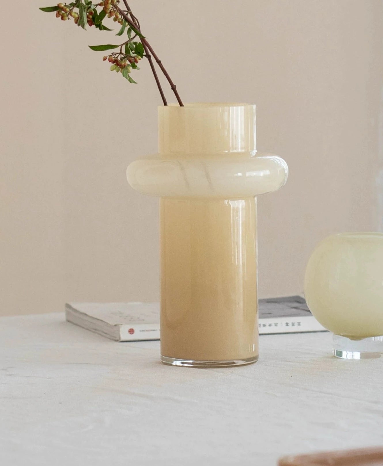 Modern glass vase in cream, ideal for home décor.