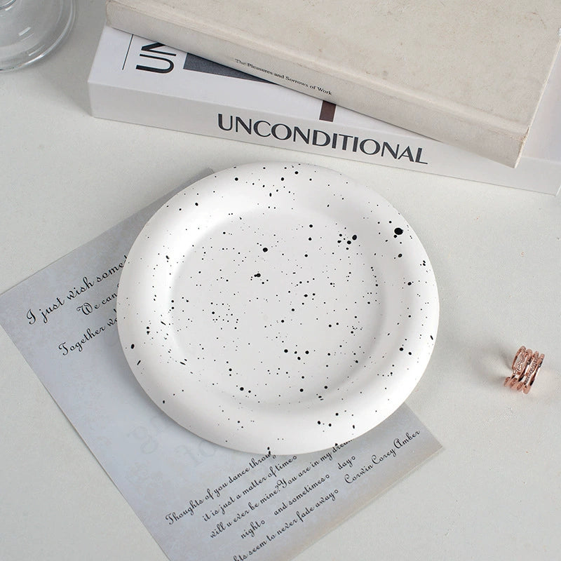 A collection of plaster trays from the Quinto Tray Collection, featuring various shapes and neutral colorways, suitable for use in different areas of the home.