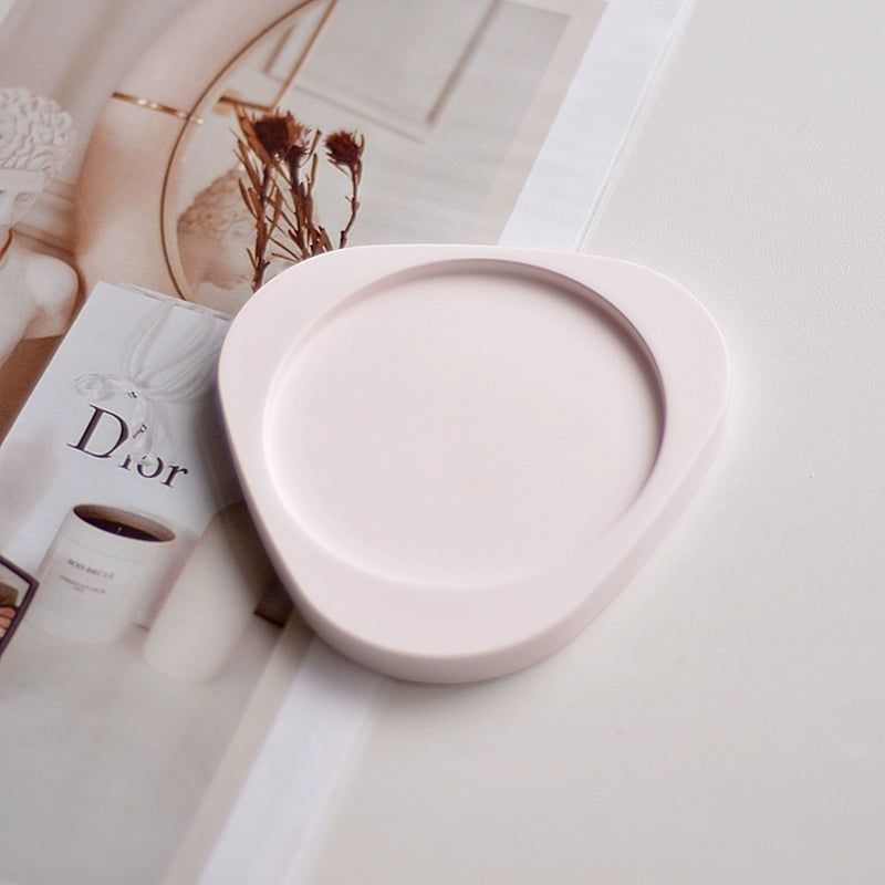A collection of plaster trays from the Quinto Tray Collection, featuring various shapes and neutral colorways, suitable for use in different areas of the home.