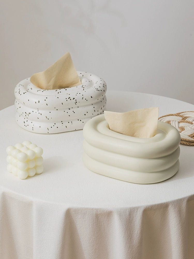 A modern ceramic tissue box cover with an oval shape, available in various stylish colorways. The cover adds a touch of contemporary elegance to home decor, seamlessly concealing tissue boxes while maintaining functional and chic design.