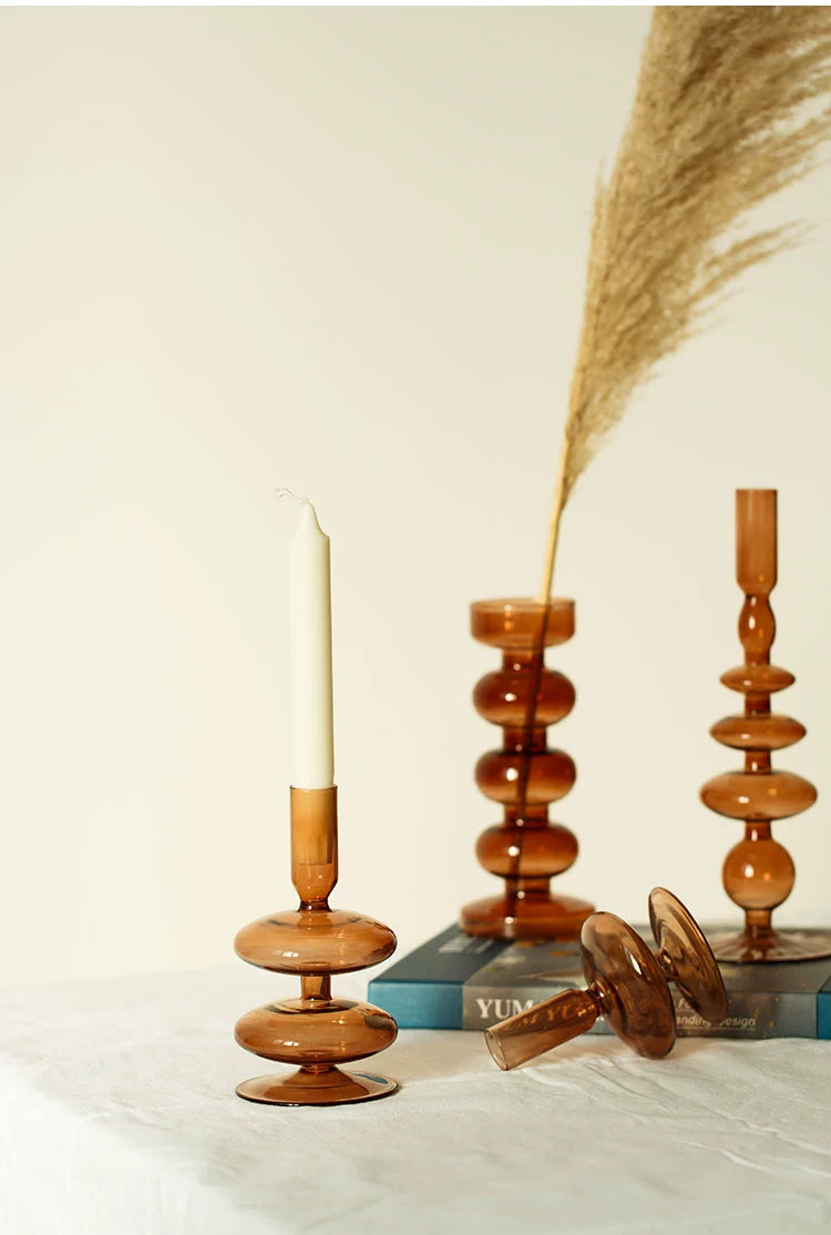 A brown glass Rhea Candle Holder set, featuring four different silhouettes in various sizes, creating a warm and inviting retro ambiance.