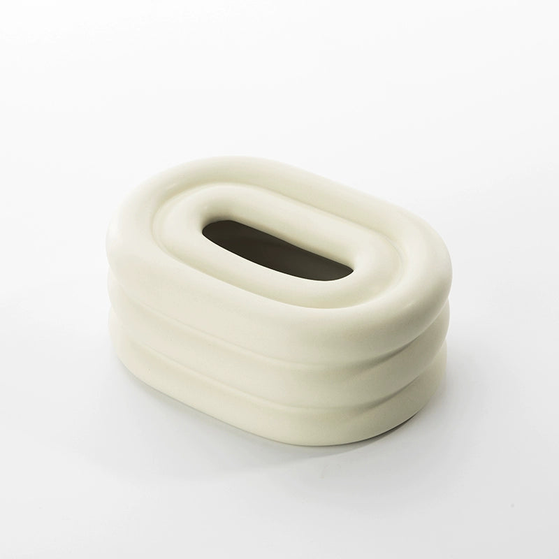 A modern ceramic tissue box cover with an oval shape, available in various stylish colorways. The cover adds a touch of contemporary elegance to home decor, seamlessly concealing tissue boxes while maintaining functional and chic design.