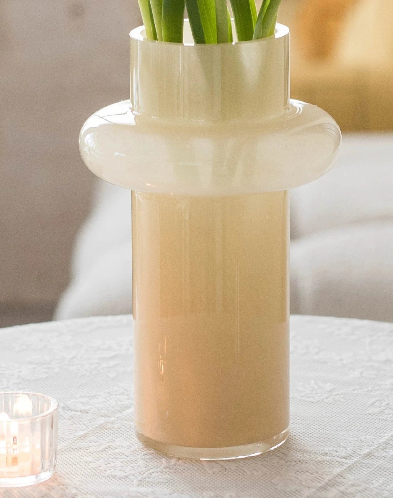 Modern glass vase in cream, ideal for home décor.