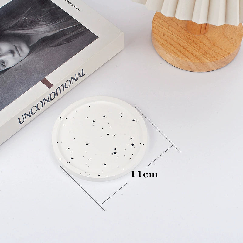 A collection of plaster trays from the Quinto Tray Collection, featuring various shapes and neutral colorways, suitable for use in different areas of the home.