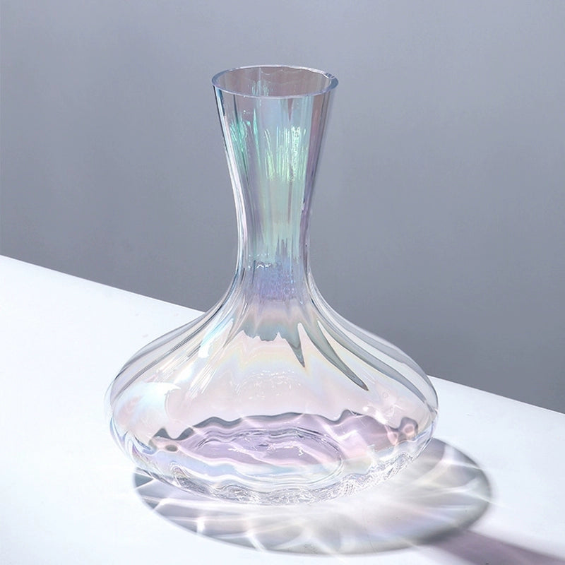 A collection of iridescent glassware from Domus Forge, featuring wine glasses, champagne coupes, decanters, and highball glasses in pastel gradient hues.
