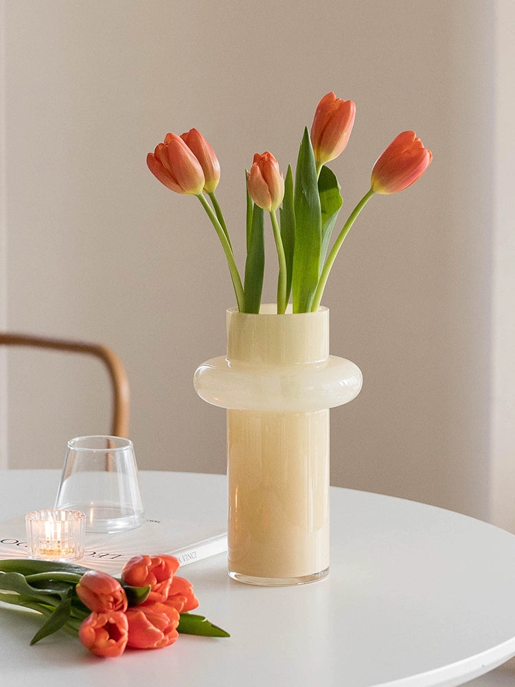 Modern glass vase in cream, ideal for home décor.