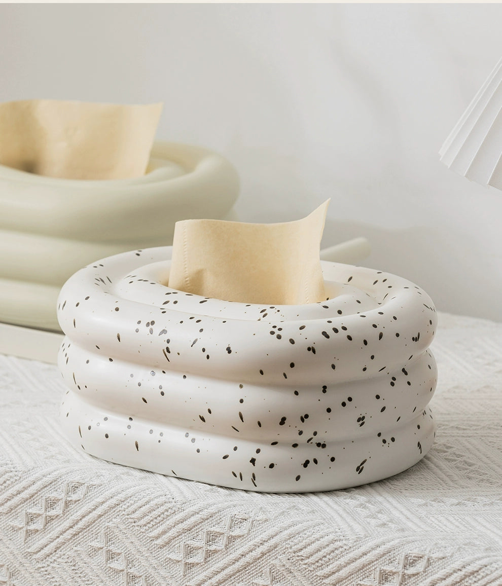 A modern ceramic tissue box cover with an oval shape, available in various stylish colorways. The cover adds a touch of contemporary elegance to home decor, seamlessly concealing tissue boxes while maintaining functional and chic design.