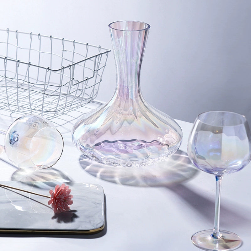 A collection of iridescent glassware from Domus Forge, featuring wine glasses, champagne coupes, decanters, and highball glasses in pastel gradient hues.