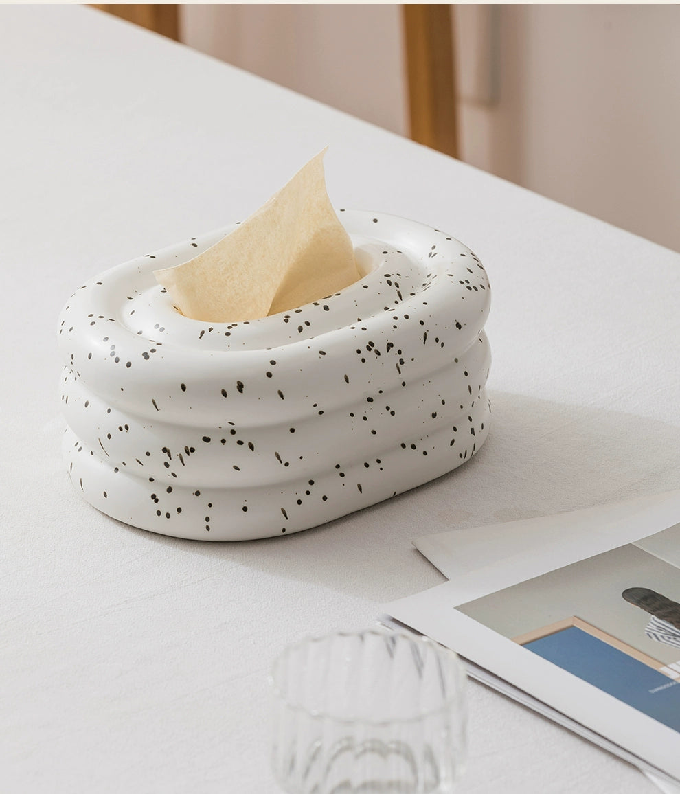 A modern ceramic tissue box cover with an oval shape, available in various stylish colorways. The cover adds a touch of contemporary elegance to home decor, seamlessly concealing tissue boxes while maintaining functional and chic design.