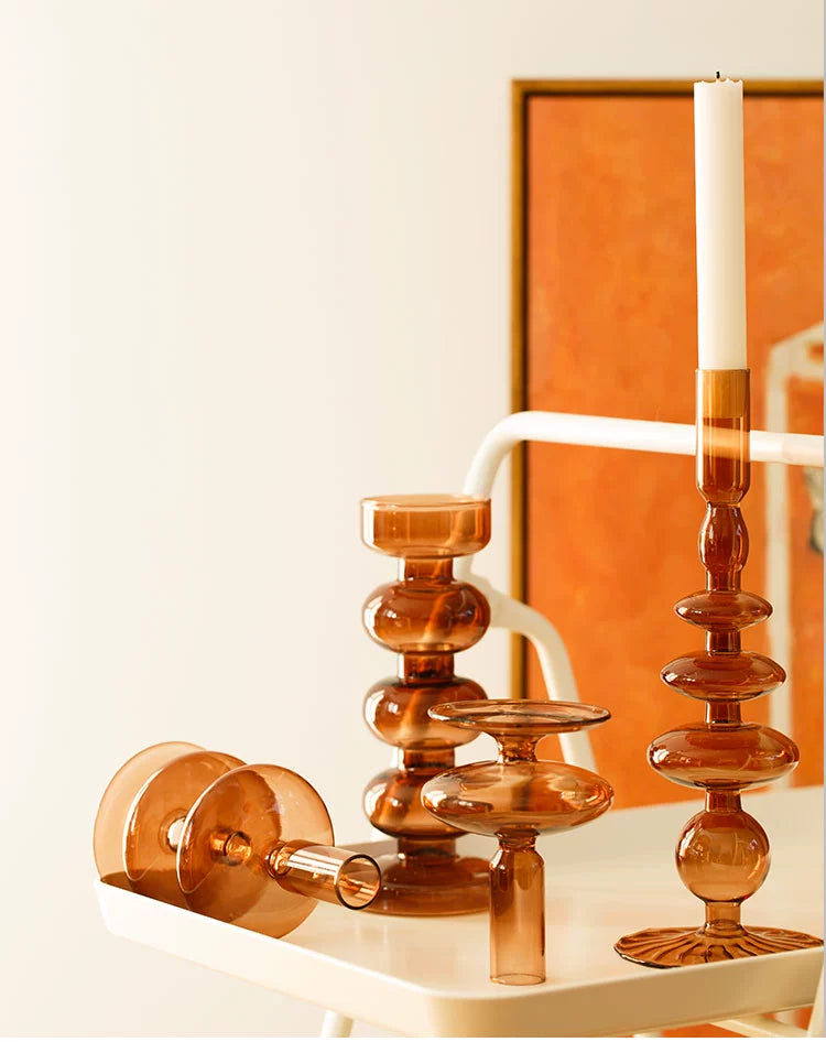 A brown glass Rhea Candle Holder set, featuring four different silhouettes in various sizes, creating a warm and inviting retro ambiance.