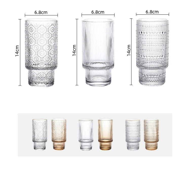 Image of the Unai Glass Collection featuring elegant tumbler and highball glasses. Made from laminated glass with intricate beaded or floral designs, these stackable glasses come in amber or clear colors. Available in two-piece or six-piece sets, perfect for entertaining and enhancing your home decor.