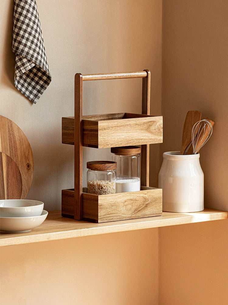 The Jacko Storage Rack features two levels made from solid acacia wood with a warm brown tone. Its simple and minimalist design makes it perfect for organizing countertops in kitchens, bathrooms, or any room in the home. This compact and stylish storage rack helps declutter while adding a touch of natural elegance, ideal for home décor enthusiasts seeking both functionality and aesthetic appeal.