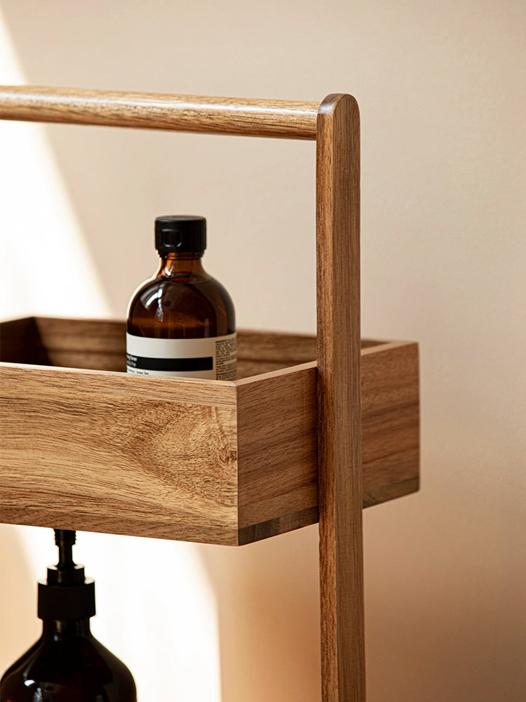 The Jacko Storage Rack features two levels made from solid acacia wood with a warm brown tone. Its simple and minimalist design makes it perfect for organizing countertops in kitchens, bathrooms, or any room in the home. This compact and stylish storage rack helps declutter while adding a touch of natural elegance, ideal for home décor enthusiasts seeking both functionality and aesthetic appeal.
