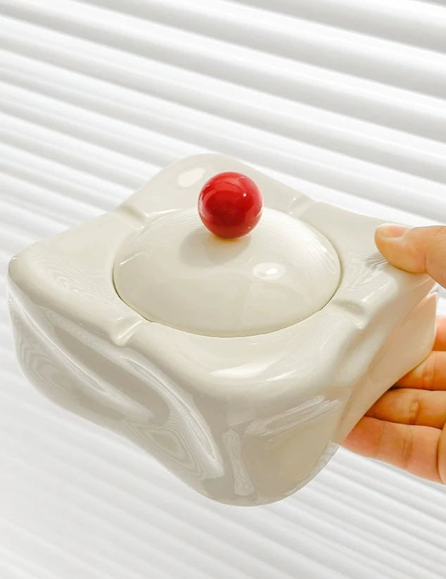 Foresta Ceramic Ashtray with cute ball detail, irregular shape, and modern design. Available in various colorways, choose between lidded or lidless options to suit your style. Crafted from high-quality ceramic for a sleek and contemporary smoking accessory.