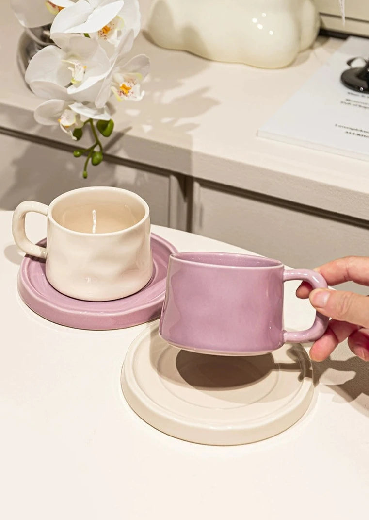 Organic-shaped cream mug & saucer set with orchid colorway, perfect for coffee & tea lovers.