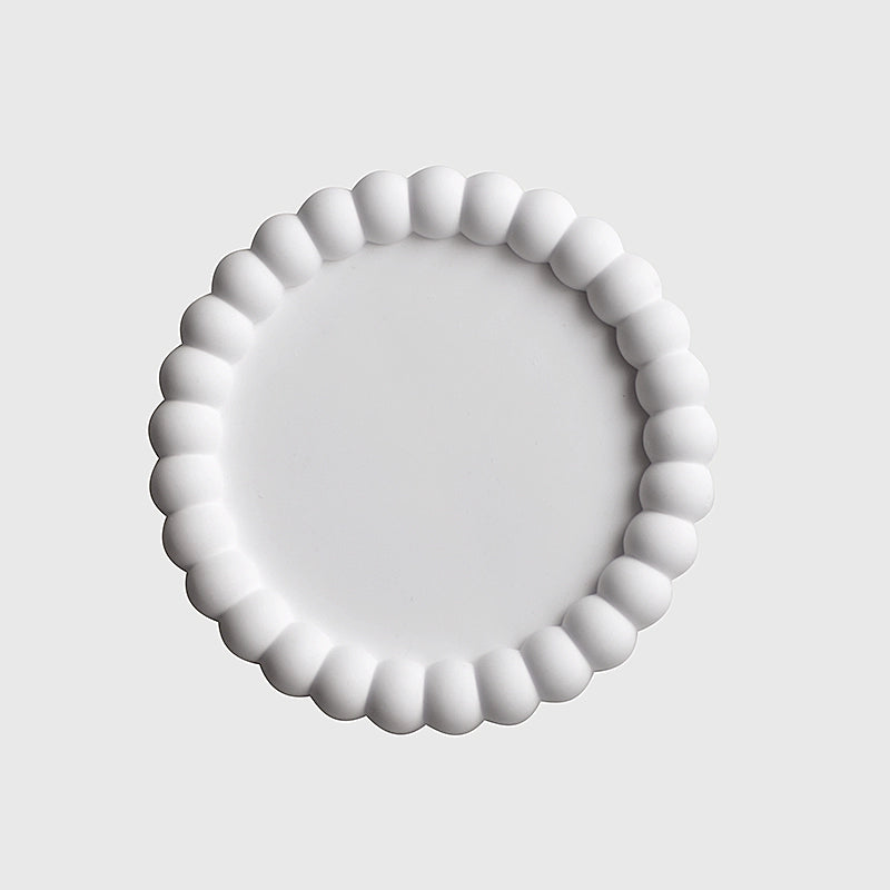 A collection of plaster trays from the Quinto Tray Collection, featuring various shapes and neutral colorways, suitable for use in different areas of the home.