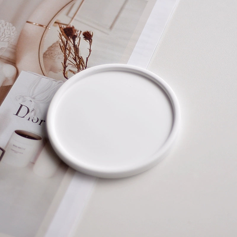 A collection of plaster trays from the Quinto Tray Collection, featuring various shapes and neutral colorways, suitable for use in different areas of the home.