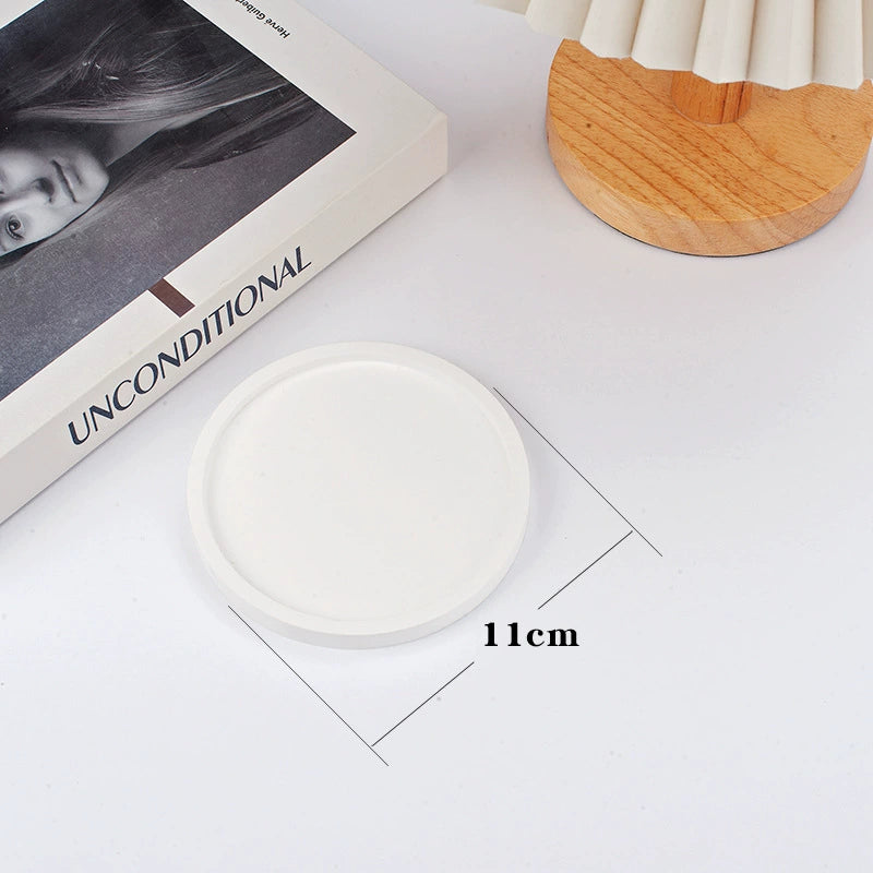 A collection of plaster trays from the Quinto Tray Collection, featuring various shapes and neutral colorways, suitable for use in different areas of the home.