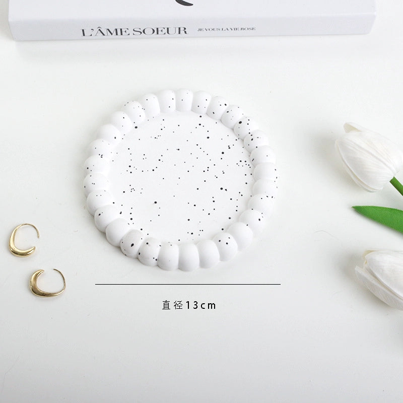 A collection of plaster trays from the Quinto Tray Collection, featuring various shapes and neutral colorways, suitable for use in different areas of the home.