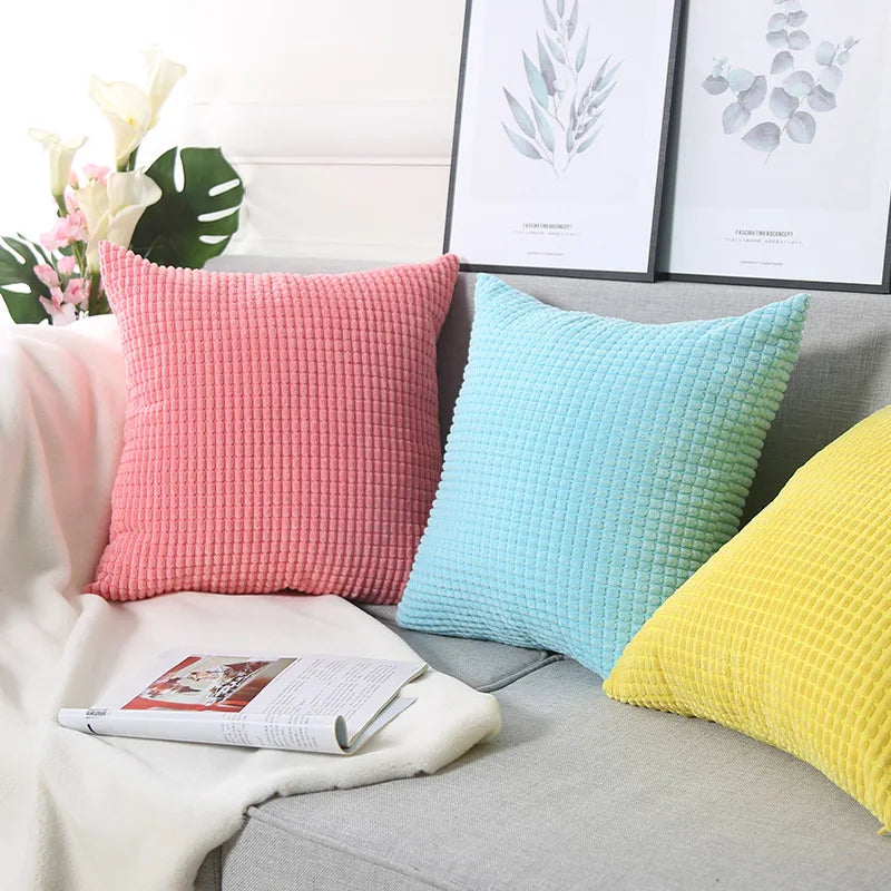 A stylish Warren Pillow Cover displayed on a couch, showcasing its soft corduroy corn grain texture. Available in various colorways and sizes, this square pillow cover adds warmth and elegance to any space. Ideal for home décor enthusiasts, it enhances living areas with a cozy, inviting touch. Please note that the pillow insert is not included.
