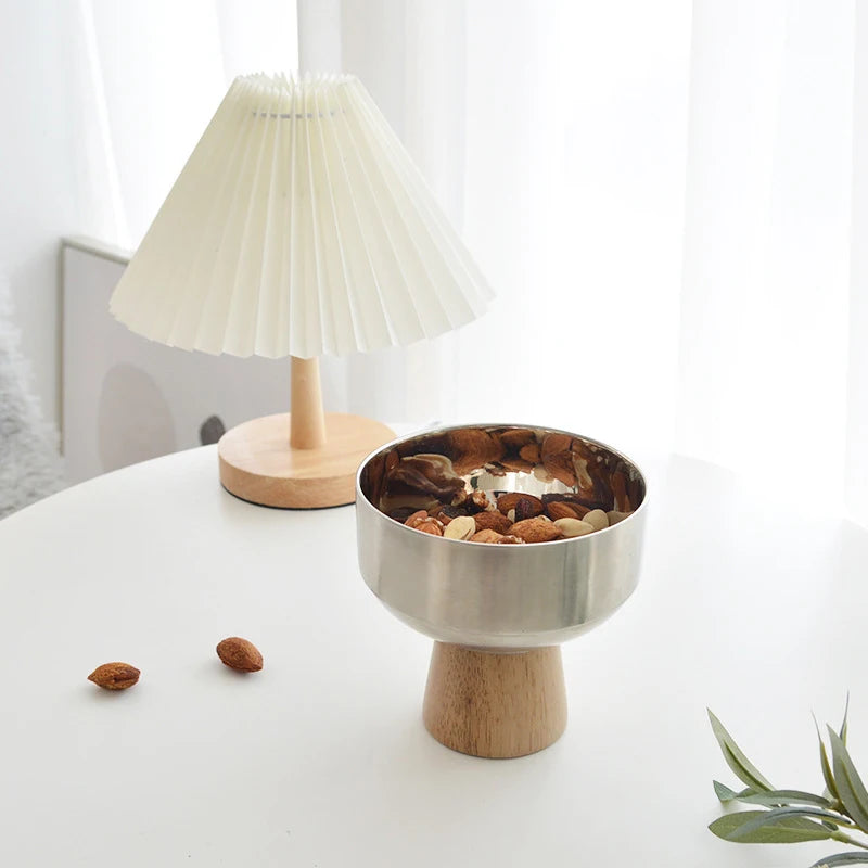 Eddard Serving Bowl featuring a modern design with a sleek stainless steel bowl and a sturdy wooden base. Compact and stylish, this small serving bowl is perfect for home decor enthusiasts looking to add a chic touch to their kitchen or coffee table. Ideal for serving snacks, fruits, or side dishes.
