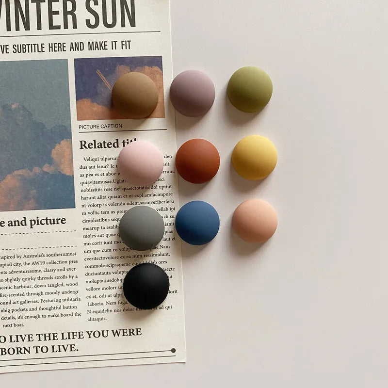 Image of the Dorina Magnets, featuring a set of 10 circular magnets in random vibrant colors. Each magnet measures 1.8 cm in diameter and is ideal for use in kitchens or offices, perfect for securing notes, lists, and reminders to metallic surfaces. A stylish and functional accessory for organizing spaces.
