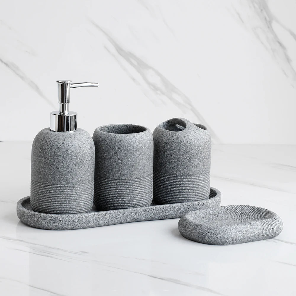 Inga Bath Set – five-piece resin bathroom set in neutral tones, including a tray, soap dish, dispenser, tumbler, and toothbrush holder for a chic, organized space.