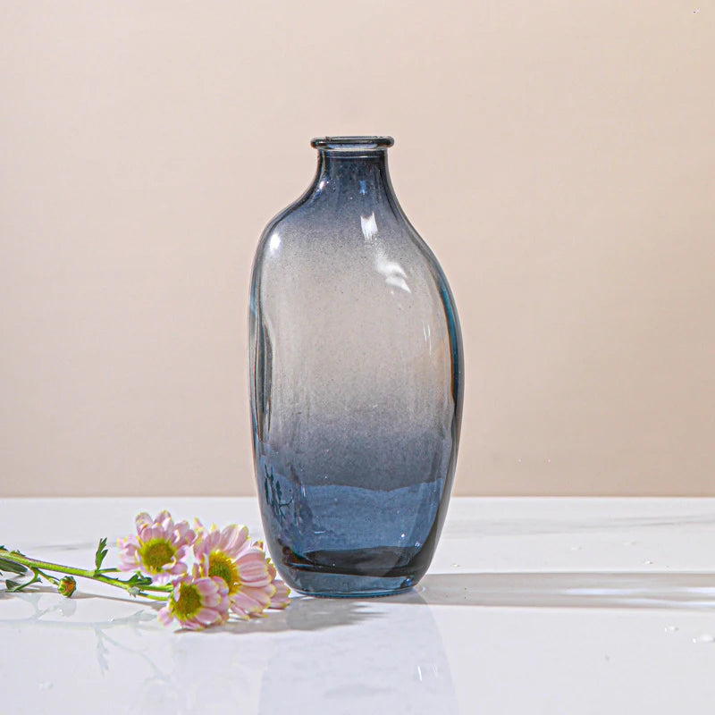 Image of the Raynis Vase, a small glass vase available in three colorways with a gradient color finish. Featuring an organic shape, these vases come in different sizes, perfect for mixing and matching. Ideal for home décor enthusiasts looking to add an artistic and elegant touch to their living spaces.