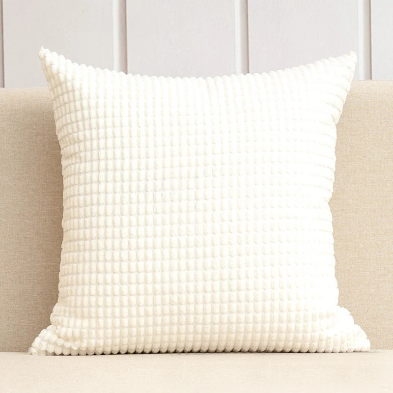 A stylish Warren Pillow Cover displayed on a couch, showcasing its soft corduroy corn grain texture. Available in various colorways and sizes, this square pillow cover adds warmth and elegance to any space. Ideal for home décor enthusiasts, it enhances living areas with a cozy, inviting touch. Please note that the pillow insert is not included.
