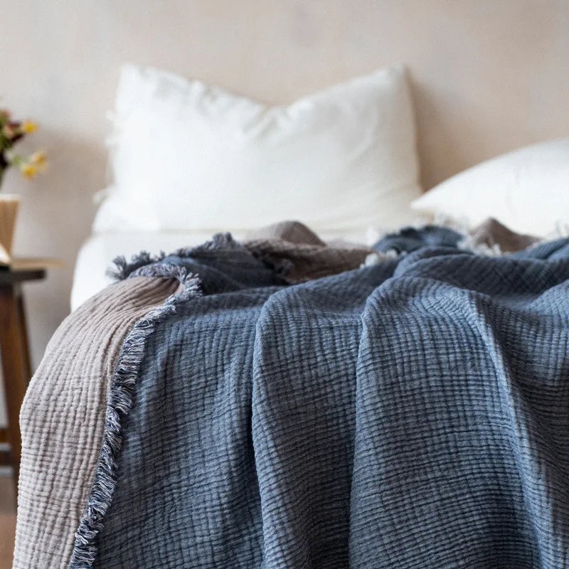 Nogu Throw Blanket – soft Maillard cotton throw with a layered gauze texture, fringe detail, and chic muted colorways, available in two sizes for cozy, stylish comfort.