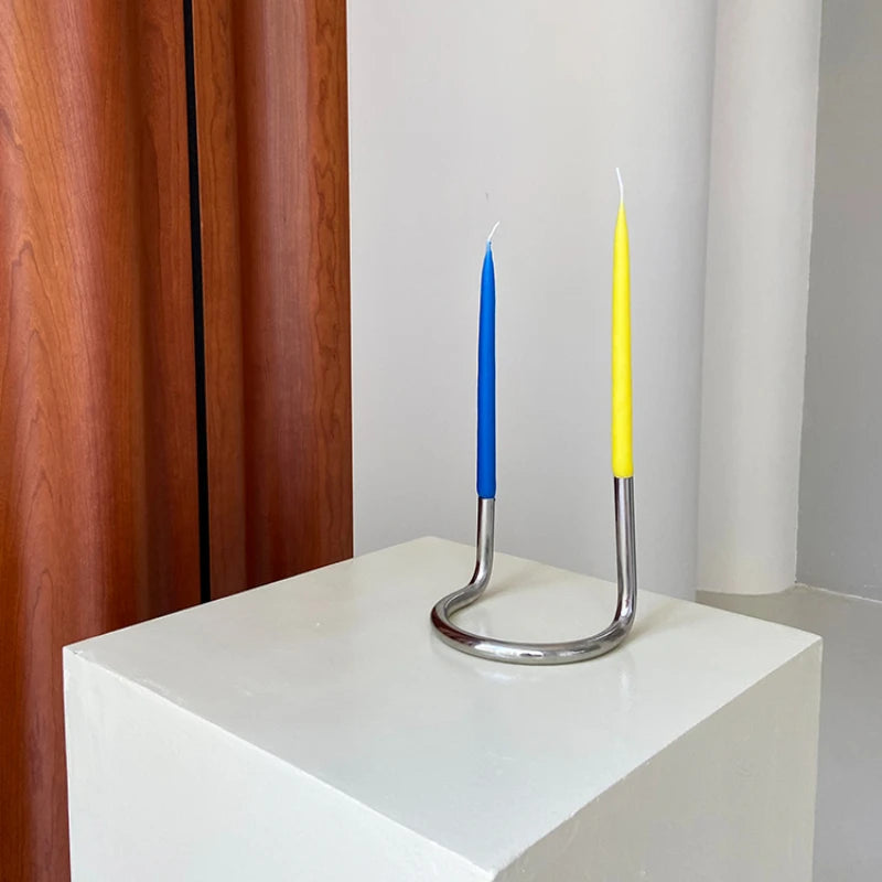 The Ivy Candle Holder features a modern, U-shaped stainless steel design that holds two candles. With a sleek, minimalist look, it is perfect for home décor enthusiasts who love contemporary accents. Ideal for creating a stylish ambiance on dinner tables, mantles, or living spaces, this candle holder blends functionality and elegance.
