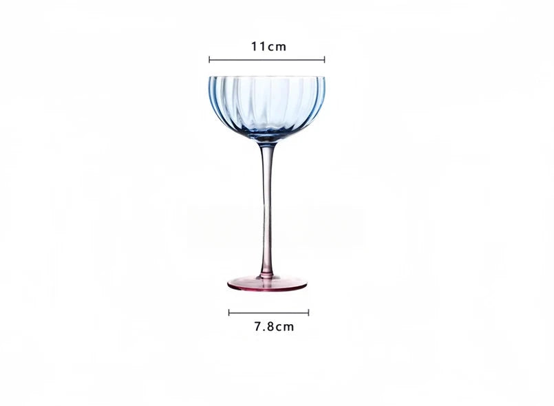 A vibrant collection of Ugo Wine Glasses displayed on a table, showcasing their fun and chic design. Each glass features a colored pastel bowl with a contrasting stem and a fluted shape. Ideal for entertaining, these glasses hold 11 fluid ounces and are perfect for mixing and matching. Designed for home décor enthusiasts, they add a playful yet elegant touch to any bar or dining setting.