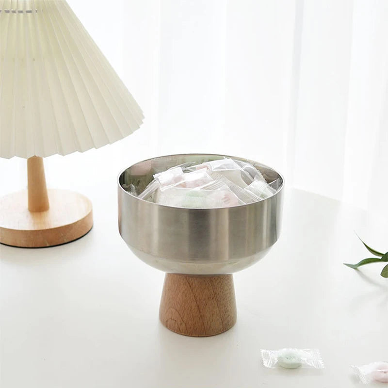 Eddard Serving Bowl featuring a modern design with a sleek stainless steel bowl and a sturdy wooden base. Compact and stylish, this small serving bowl is perfect for home decor enthusiasts looking to add a chic touch to their kitchen or coffee table. Ideal for serving snacks, fruits, or side dishes.